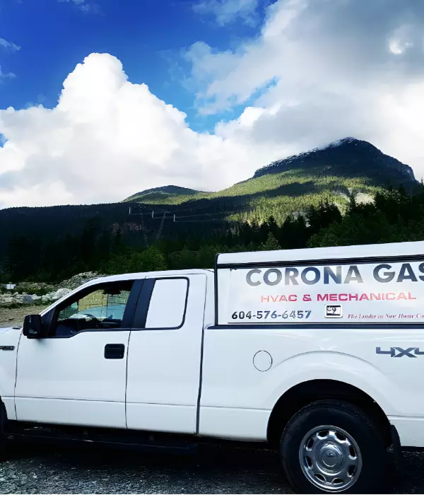 A white Corona Gas truck parked in a scenic landscape with mountains in the background.