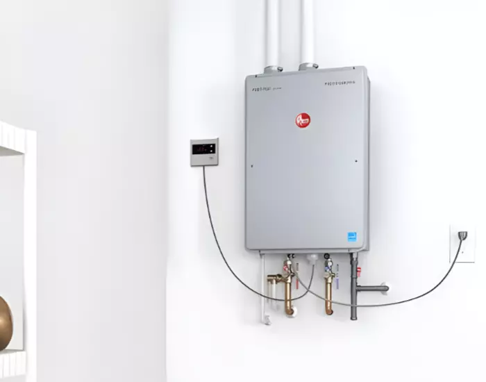 A tankless water heater mounted on a wall with a thermostat attached.