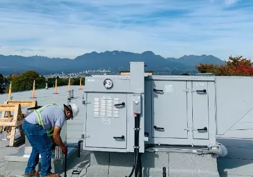 A CoronaGas HVAC technician repairs a rooftop air conditioner unit.