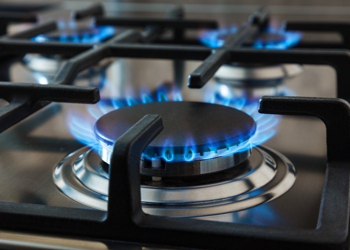 A close-up of a gas stove burner with a blue flame.