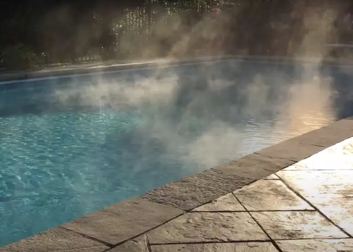 A heated swimming pool with steam rising from the water surface.